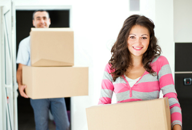couple moving into apartment carrying boxes